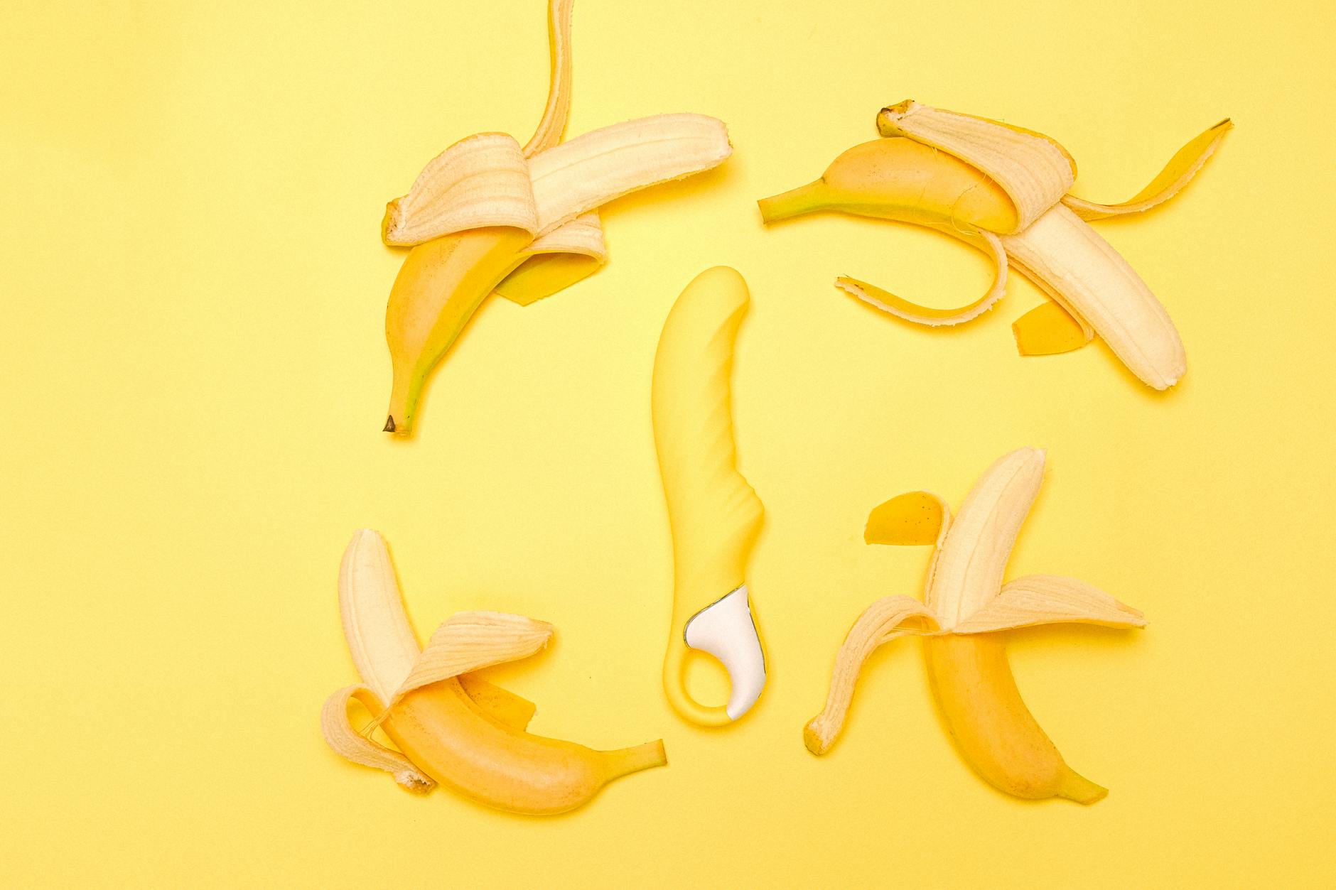 Vibrador de limão amarelo em composição criativa com limões descascados sobre fundo amarelo vibrante