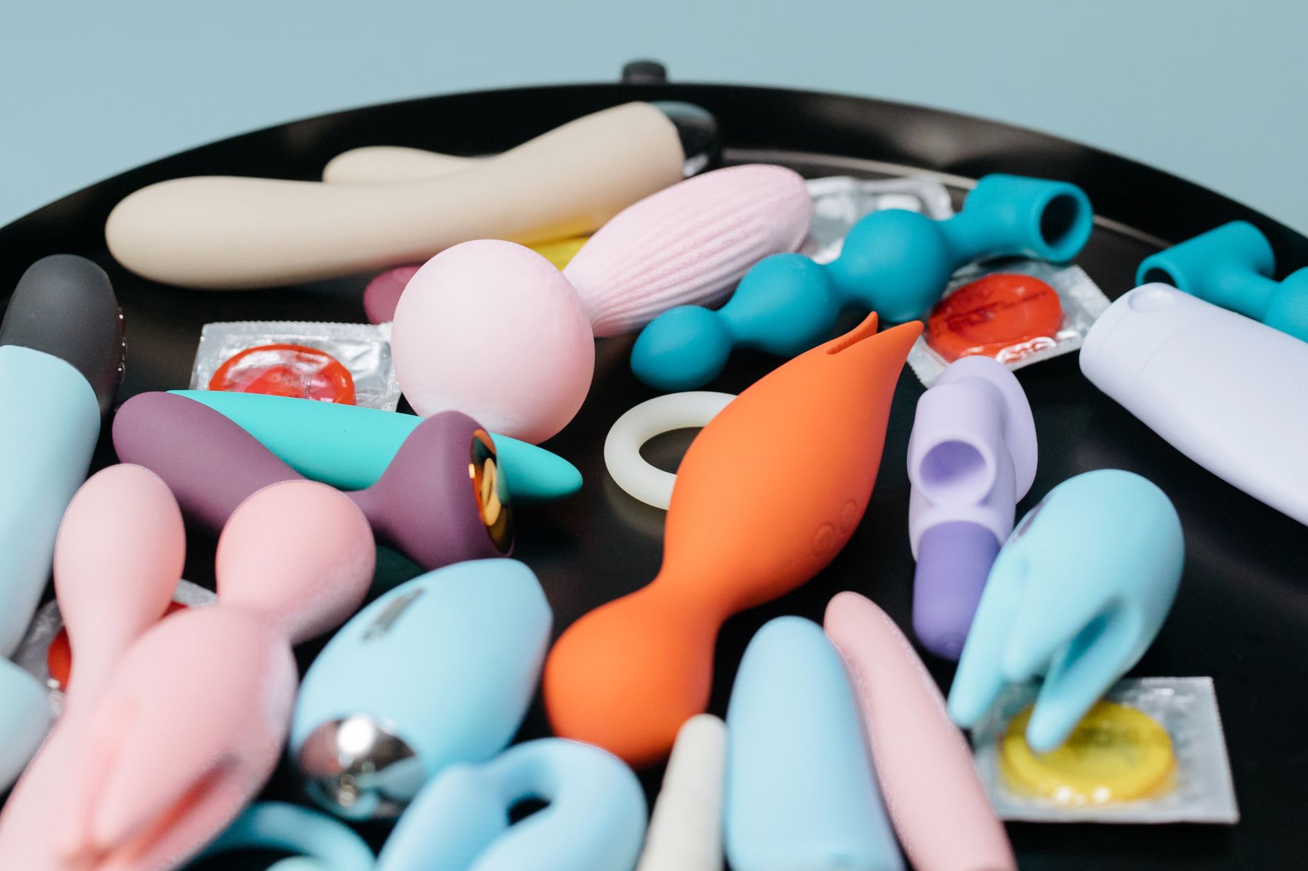 Coleção vibrante de brinquedos sexuais de várias cores e formatos em suporte preto