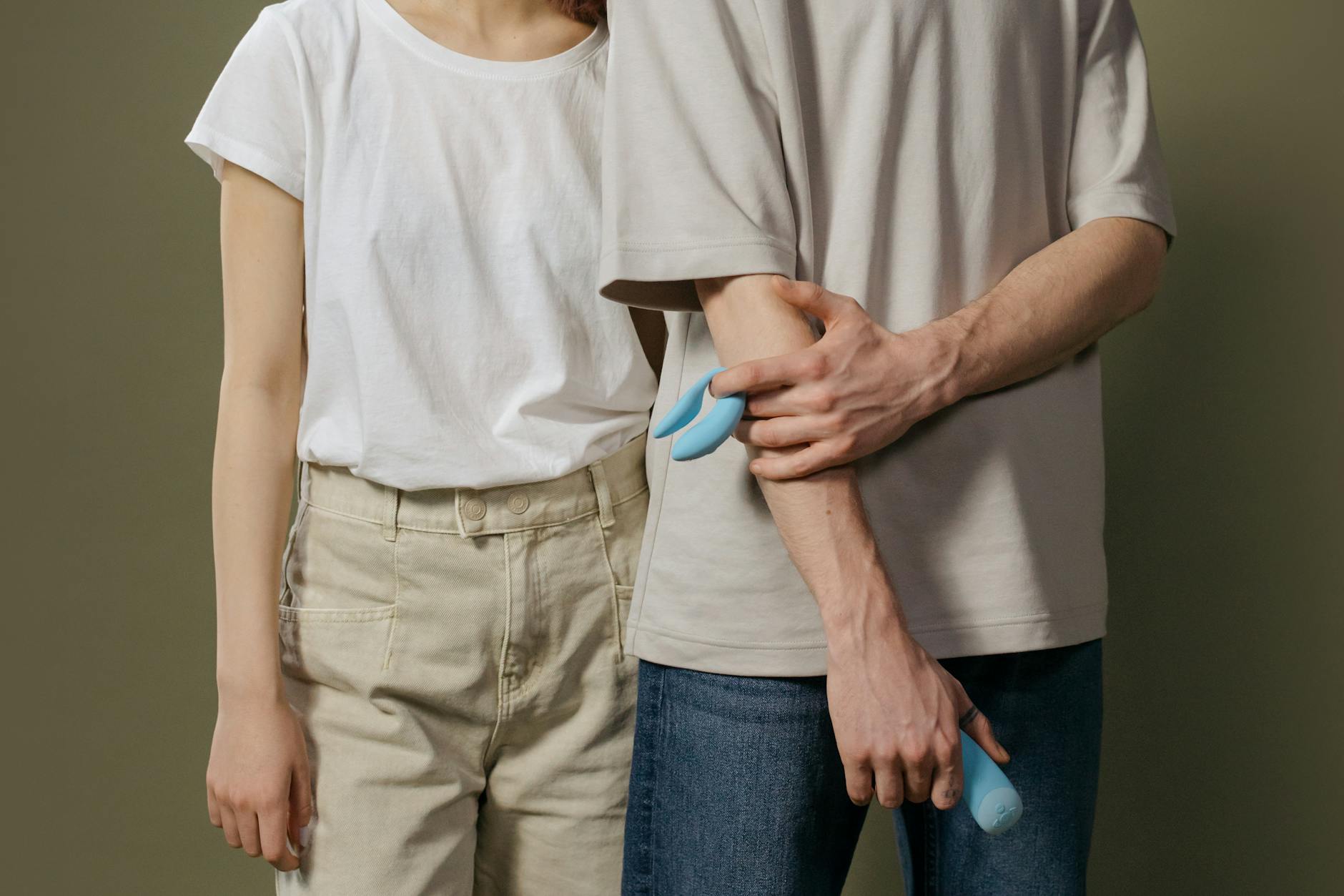 Casal jovem em pé, experimentando intimidade com um vibrador clitoriano moderno