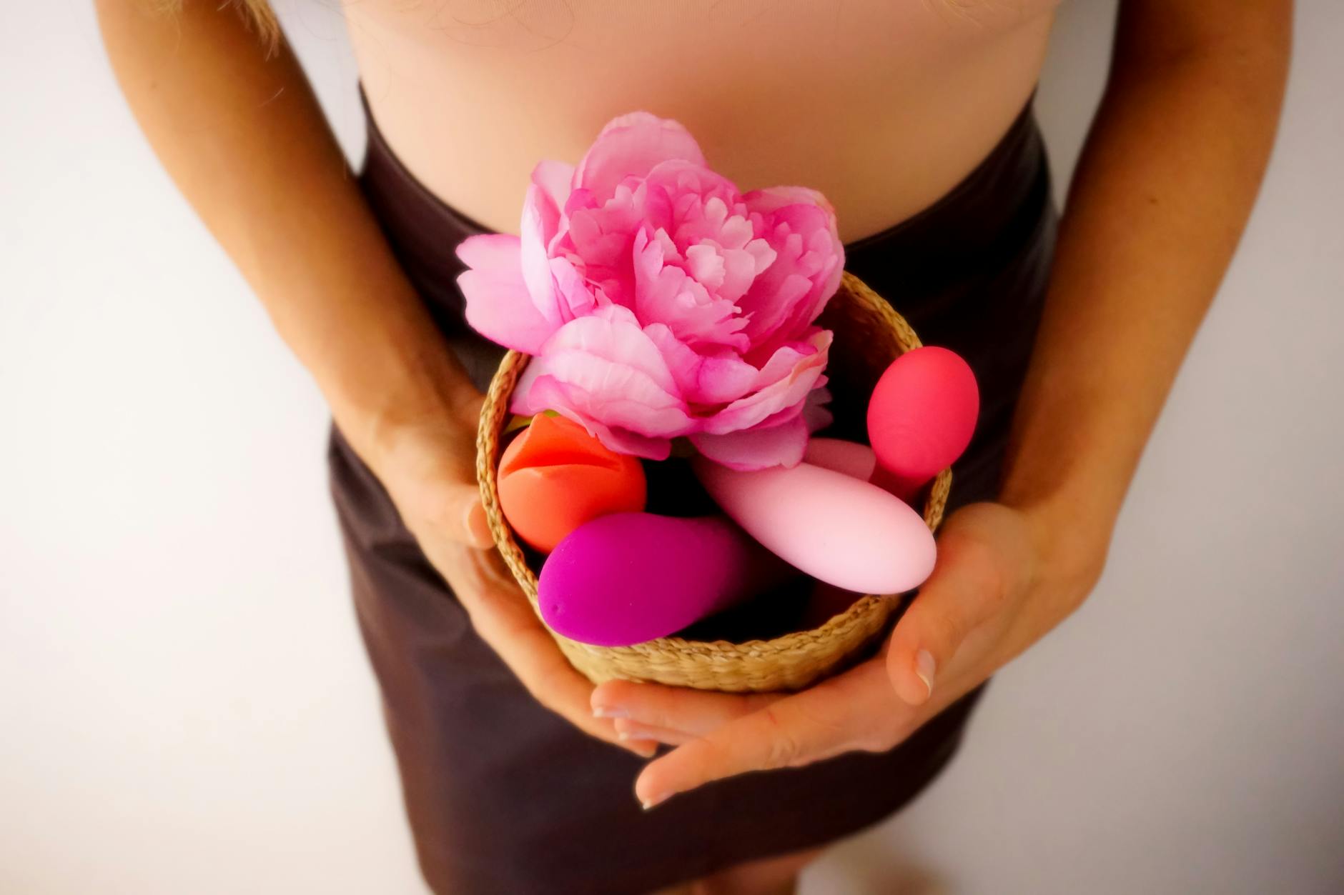 Mulher segurando vibradores de silicone azul e rosa, expressando confiança e exploração pessoal